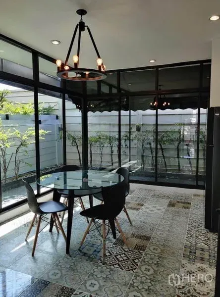 Townhouse for rent in Suan Luang, Bangkok - Corner dining room with floor-to-ceiling windows and patterned tile flooring.