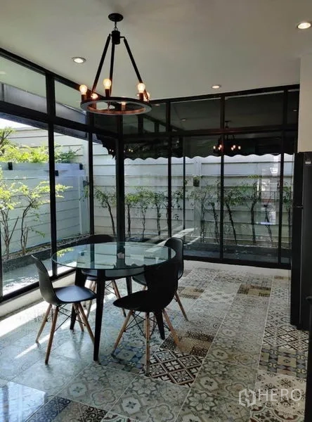 Townhouse for rent in Suan Luang, Bangkok - Corner dining room with floor-to-ceiling windows and patterned tile flooring.