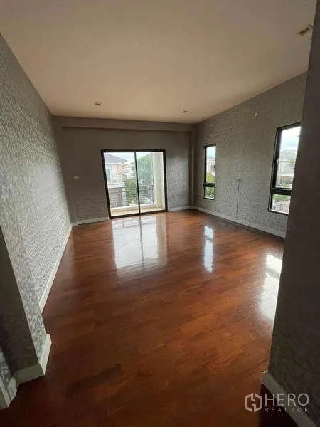 独立式住宅 出售在Lat Krabang, Bangkok - 二层房间木地板，推拉门通向阳台。