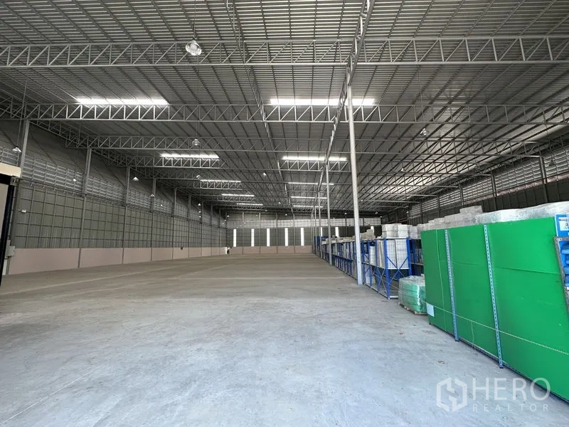 Factory for rent in Chachoengsao - Deep storage bay with racking and insulated roof panels inside the factory.