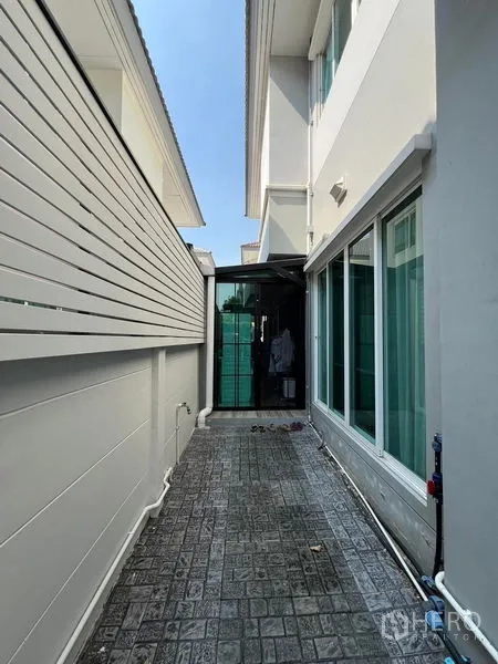 Detached House for rent or sale in Saphan Sung, Bangkok - Service side passage with tiled floor and privacy screen beside the home.
