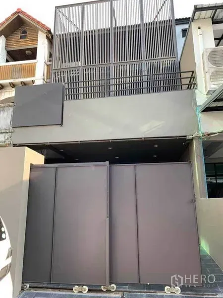 Home Office for rent in Huai Khwang, Bangkok - Modern home office facade with tall metal louver screen and sliding gate.