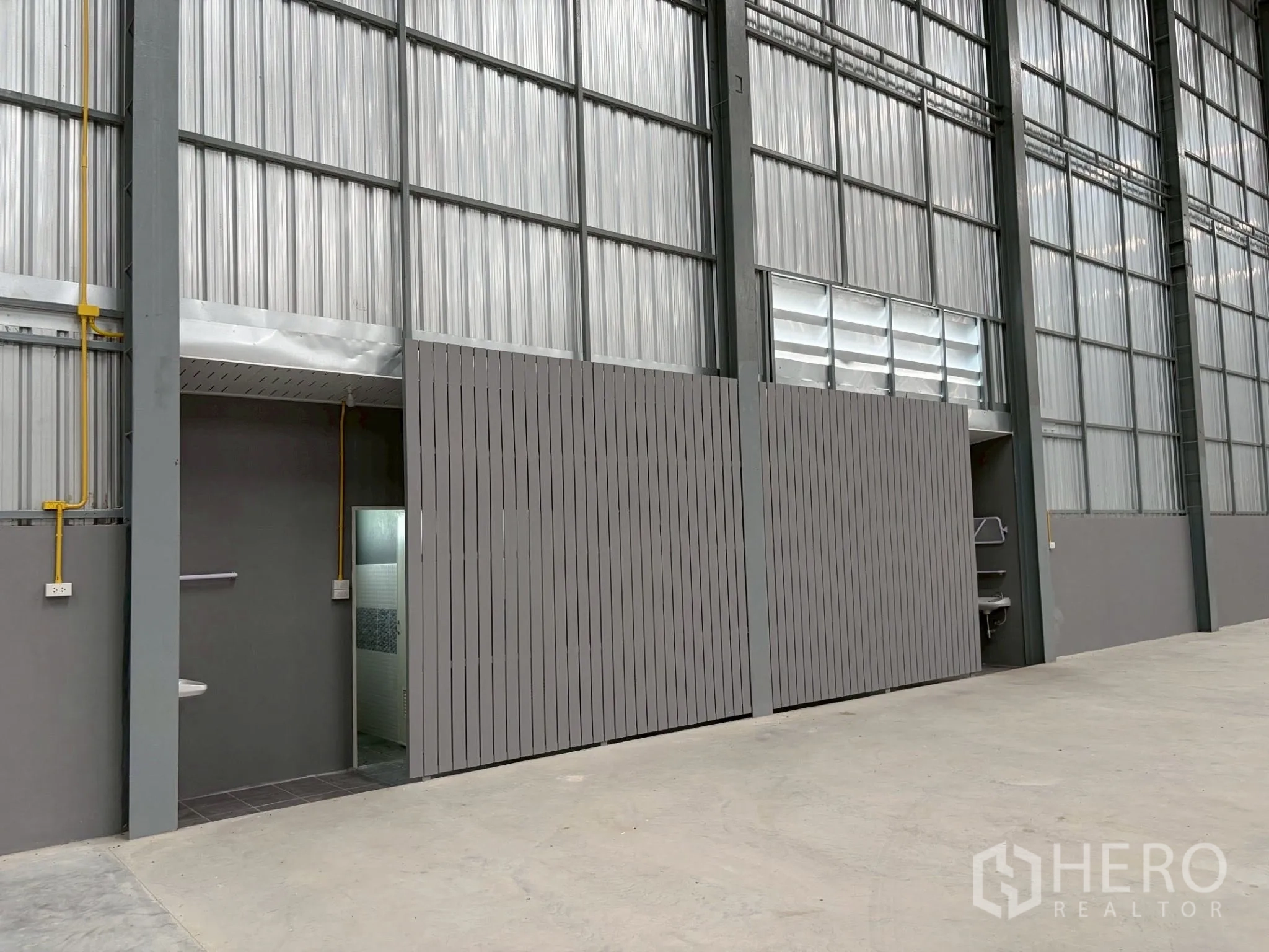 Factory for rent in Uthai, Phra Nakhon Si Ayutthaya - Interior view showing a partitioned utility area with restroom and sink inside the warehouse.