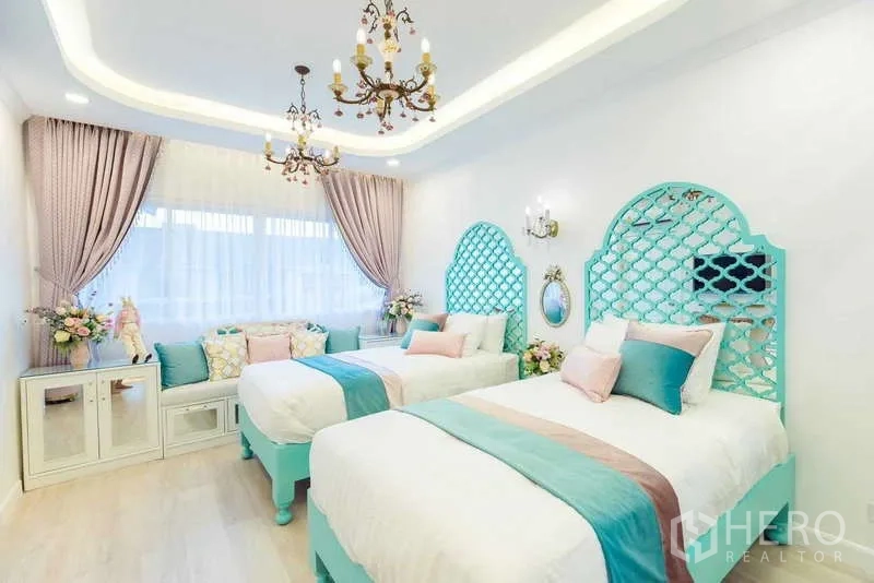 Townhouse for rent in Lat Phrao, Bangkok - Bright twin bedroom with teal lattice headboards, chandeliers and a cushioned bay window seat.