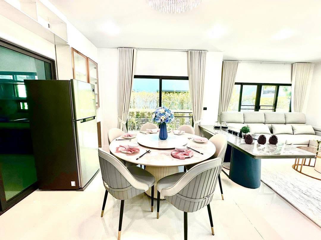 Detached House for rent in Bang Kapi, Bangkok - Dining area with round table set for six beside large windows and garden view.