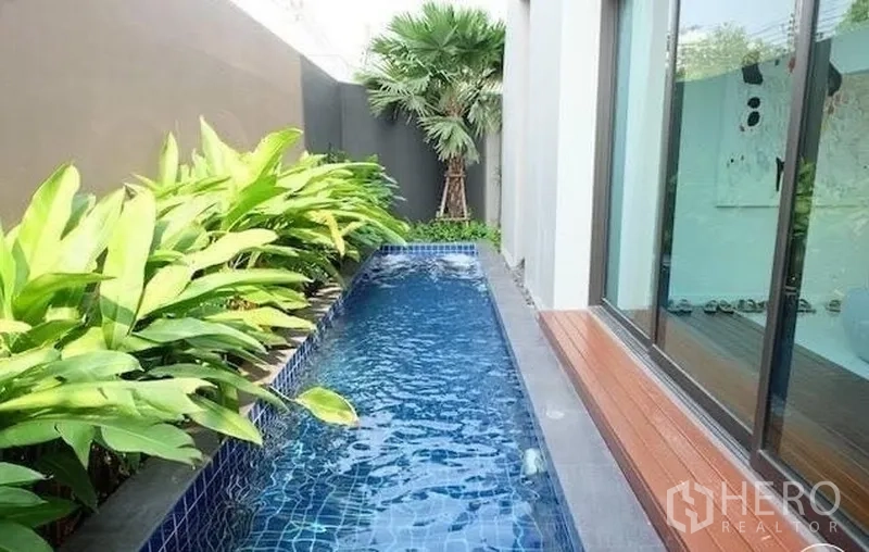 联排别墅 出租在Watthana, Bangkok - 狭长形私家浸泡泳池，木平台与热带植物