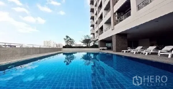 公寓 出租在Phaya Thai, Bangkok - 室外蓝色瓷砖泳池，沿公寓楼配躺椅
