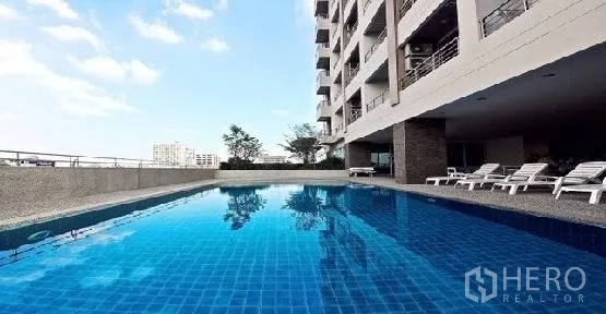 公寓 出租在Phaya Thai, Bangkok - 室外蓝色瓷砖泳池，沿公寓楼配躺椅
