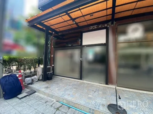 Retail Space for rent in Watthana, Bangkok - Street-facing retail storefront with frosted glass panels, covered awning and patterned tiled forecourt near Asok.