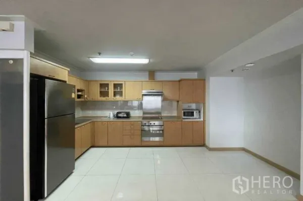公寓 出租在Watthana, Bangkok - 配备木质橱柜的不锈钢厨房，含烤箱、油烟机与大冰箱。