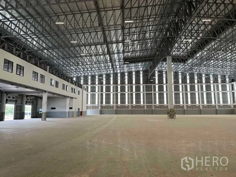 Factory for rent or sale in Samut Prakan - Expansive production floor with skylight panels and ventilated walls.
