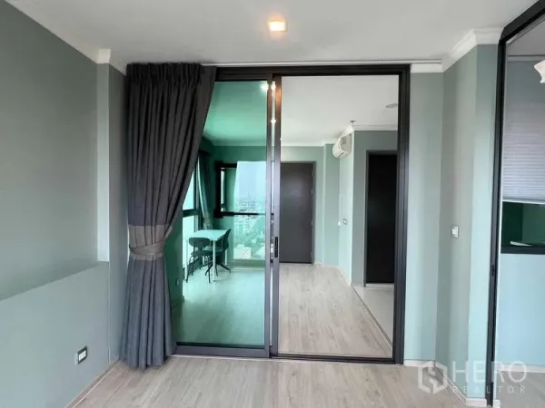 公寓 出售在Ratchathewi, Bangkok - 玻璃推拉门分隔卧室与客厅，深色窗帘与木地板