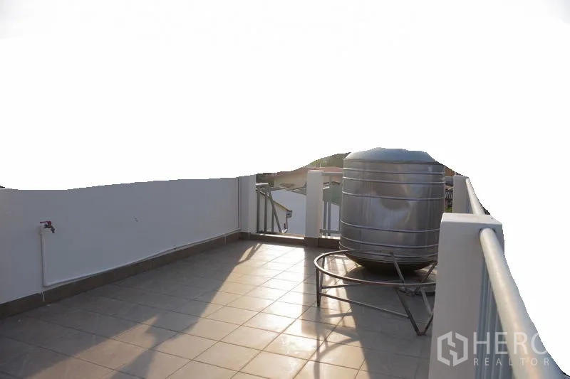 Townhouse for rent in Watthana, Bangkok - Rooftop terrace with tiled floor, railings and stainless water tank.