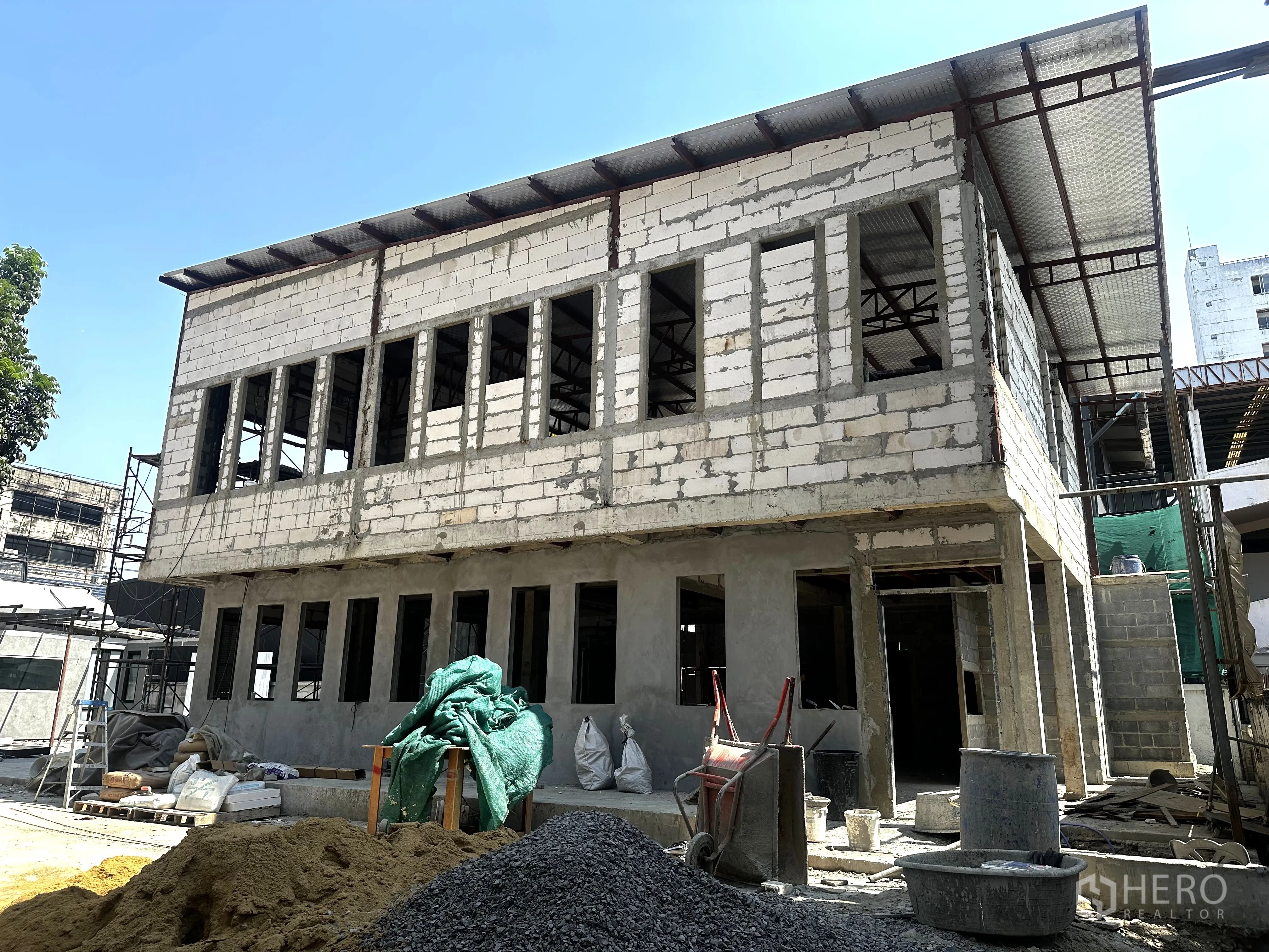 零售空间 for rent in Bang Na, Bangkok - 未完工的两层结构侧角，长排窗户与金属屋顶。