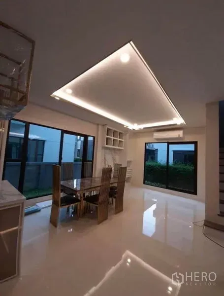 บ้าน ให้เช่าหรือขายในPrawet, Bangkok - มุมรับประทานอาหาร โต๊ะกระจก ไฟซ่อน LED และหน้าต่างสูงจรดพื้นเปิดสู่สวน