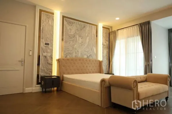 Detached House for rent or sale in Saphan Sung, Bangkok - Elegant master bedroom with tufted bed, bench seating and marble feature wall.