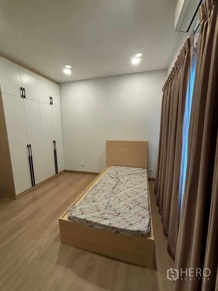 独立式住宅 出租在Mueang Nonthaburi, Nonthaburi - 卧室配单人床、嵌入式衣柜与全落地窗帘。