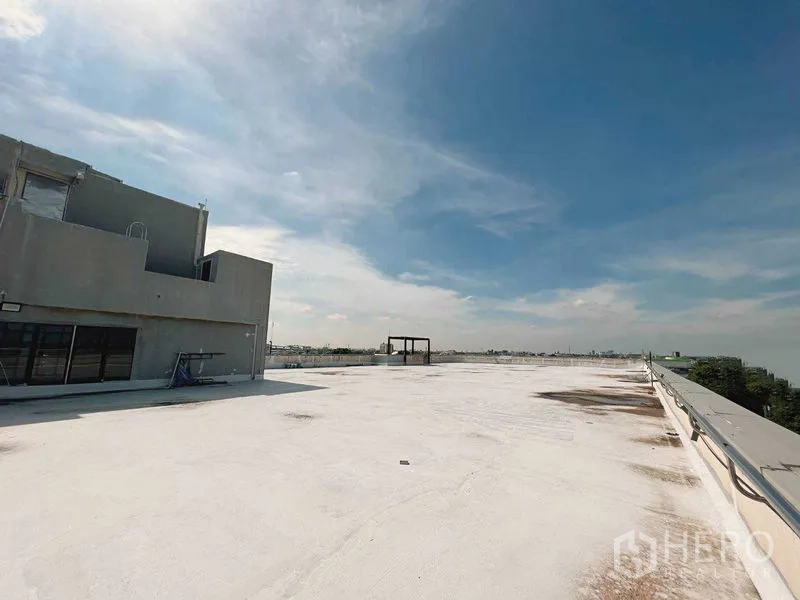 Retail Space for rent in Yan Nawa, Bangkok - Expansive white-coated rooftop deck with building core and safety railing under blue sky in Yan Nawa, Bangkok.