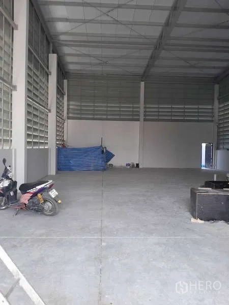 Warehouse for rent or sale in Krathum Baen, Samut Sakhon - Spacious high-ceiling warehouse interior with concrete flooring and ventilation glass-block walls.