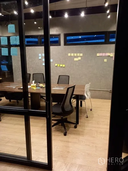 Office Space for rent in Chatuchak, Bangkok - Conference space viewed through sliding glass doors with track lighting and chairs.