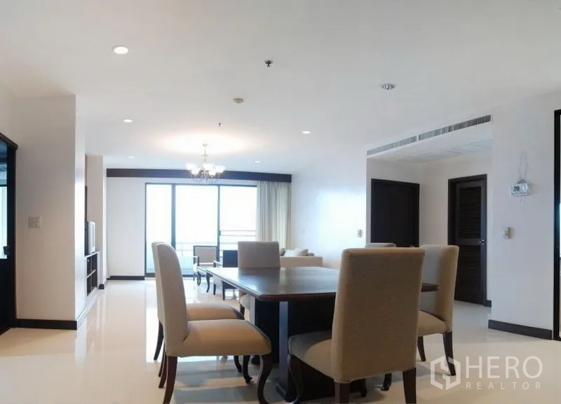 公寓 出租在Watthana, Bangkok - 明亮的客餐厅一体空间，吊灯与落地窗通向阳台
