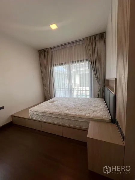 Detached House for rent or sale - Cozy bedroom with platform bed and full-length curtains.