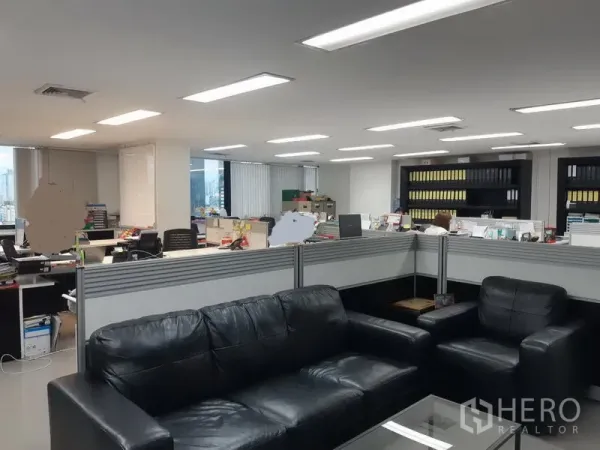 Office Space for sale in Khlong Toei, Bangkok - Reception lounge with black leather sofas beside shared workstations and storage shelves.