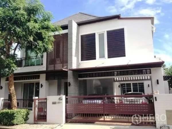 Detached House for rent or sale in Prawet, Bangkok - Front facade with gated driveway and covered carport for two cars.