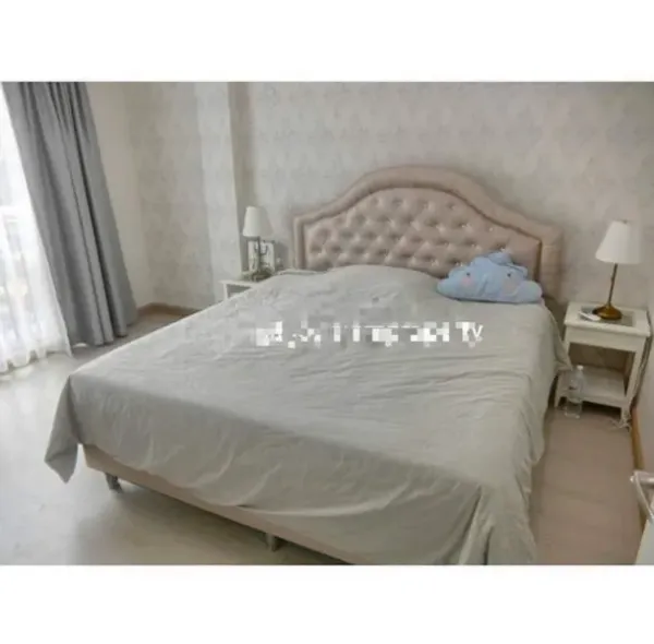 Townhouse for rent in Bang Kapi, Bangkok - Bright bedroom with tufted headboard, bedside tables and sheer curtains.