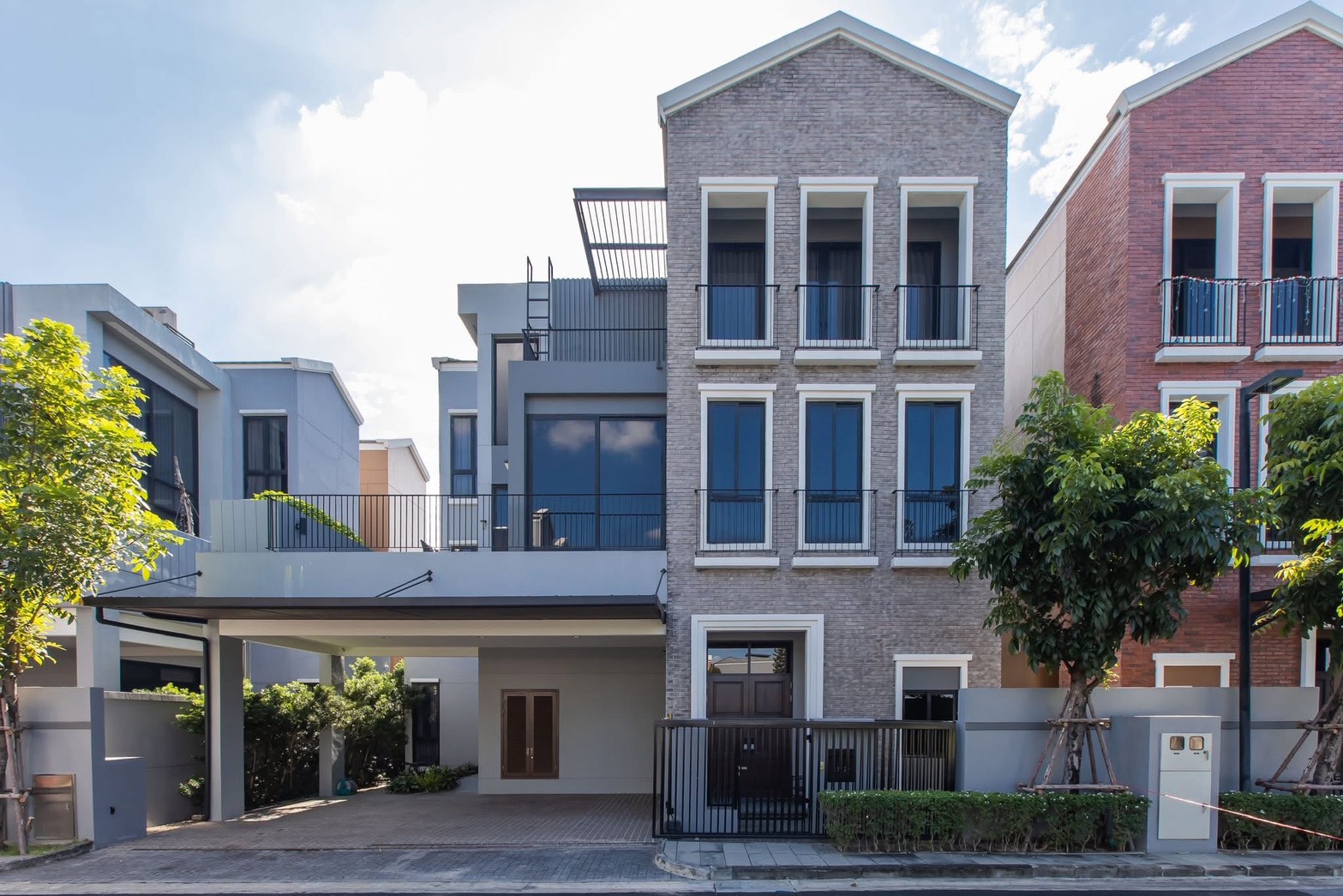独立式住宅 出租在Lat Phrao, Bangkok - 现代独栋外立面，砖饰面，大窗与阳台，带有顶棚车位。