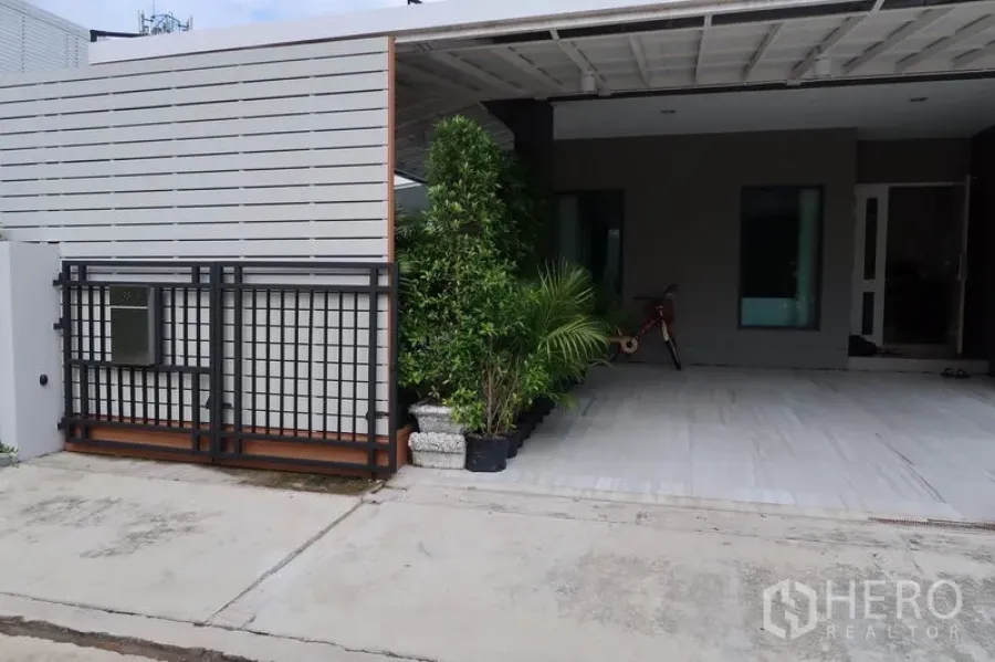 独立式住宅 出租在Prawet, Bangkok - 普拉威区现代庭院大门与有顶车位，绿植点缀
