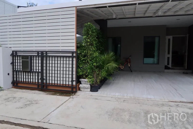 独立式住宅 出租在Prawet, Bangkok - 普拉威区现代庭院大门与有顶车位，绿植点缀
