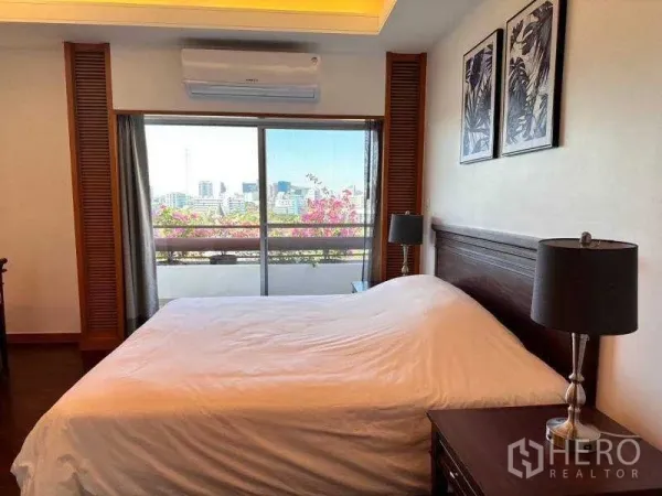Apartment for rent - Primary bedroom with city‑view balcony, sliding glass doors and bedside lamps near Lumphini Park.