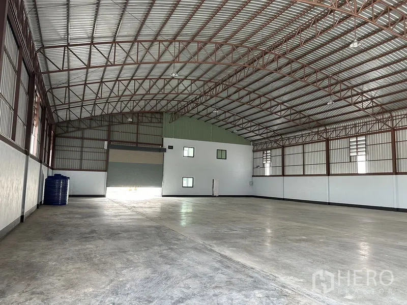 Factory for rent or sale in Sai Noi, Nonthaburi - Wide internal view of clear‑span production area with louvered side windows and smooth floors.