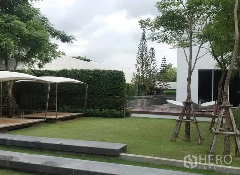 Townhouse for rent in Suan Luang, Bangkok - Landscaped communal garden with lawn, shade pavilion and mature trees at the townhouse project.