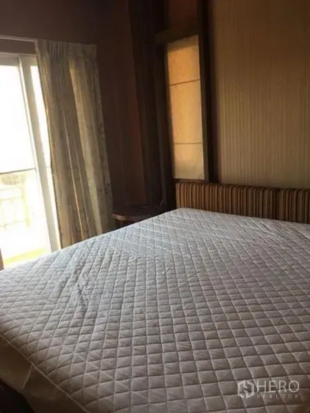 Detached House for rent in Bang Kapi, Bangkok - Bedroom with a large bed, sliding glass door to a balcony and curtains.
