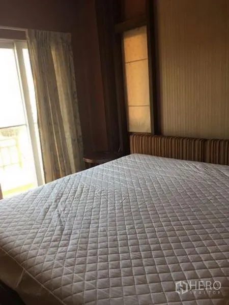 Detached House for rent in Bang Kapi, Bangkok - Bedroom with a large bed, sliding glass door to a balcony and curtains.