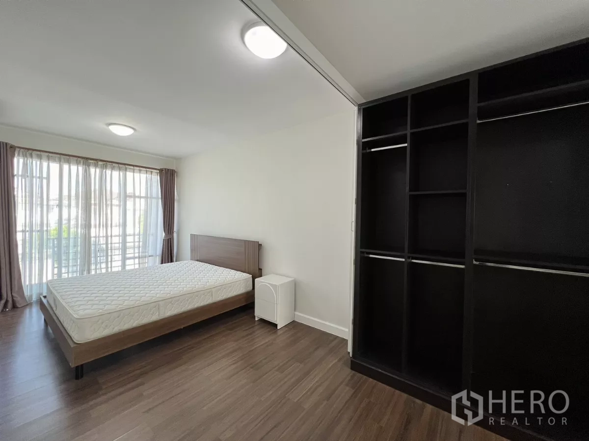 Townhouse for rent in Bang Kapi, Bangkok - Master bedroom with large windows and open wardrobe system.