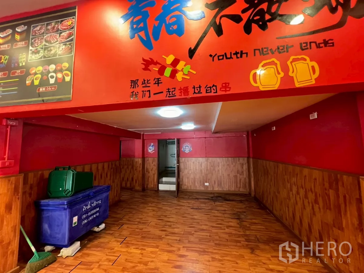 店屋 出租在Watthana, Bangkok - 一层走廊，木地板与醒目红色标识
