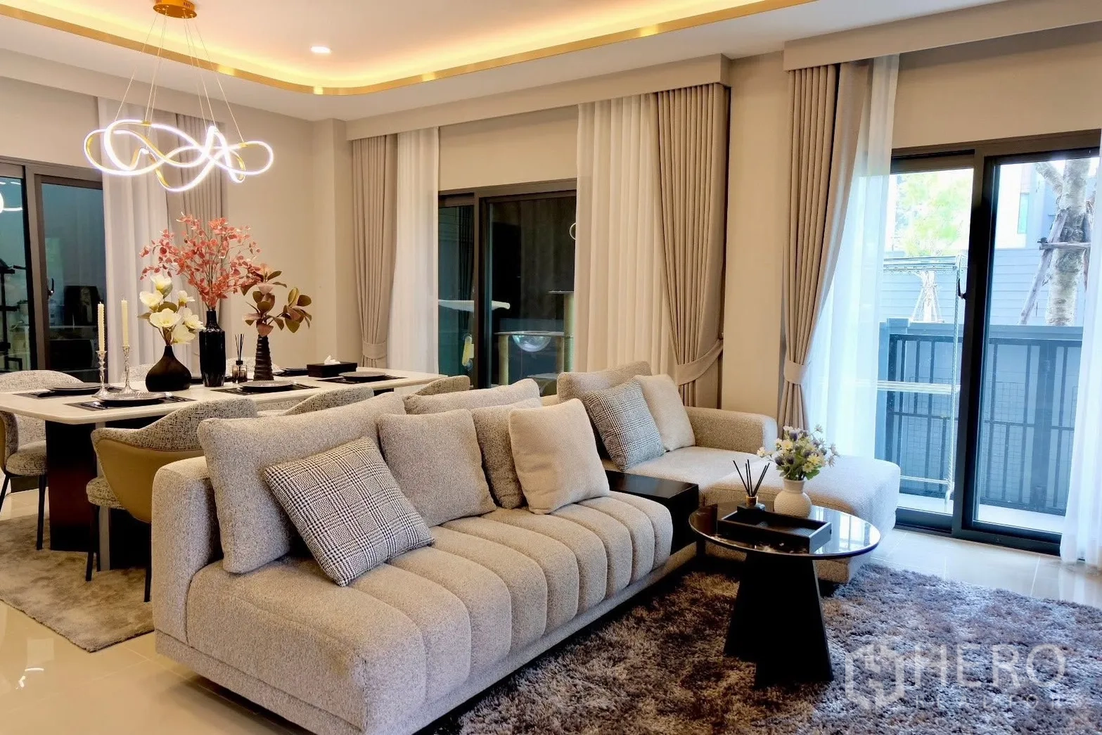 半独立式住宅 for sale in Prawet, Bangkok - 舒适客厅，大型沙发与推拉落地门及窗帘。