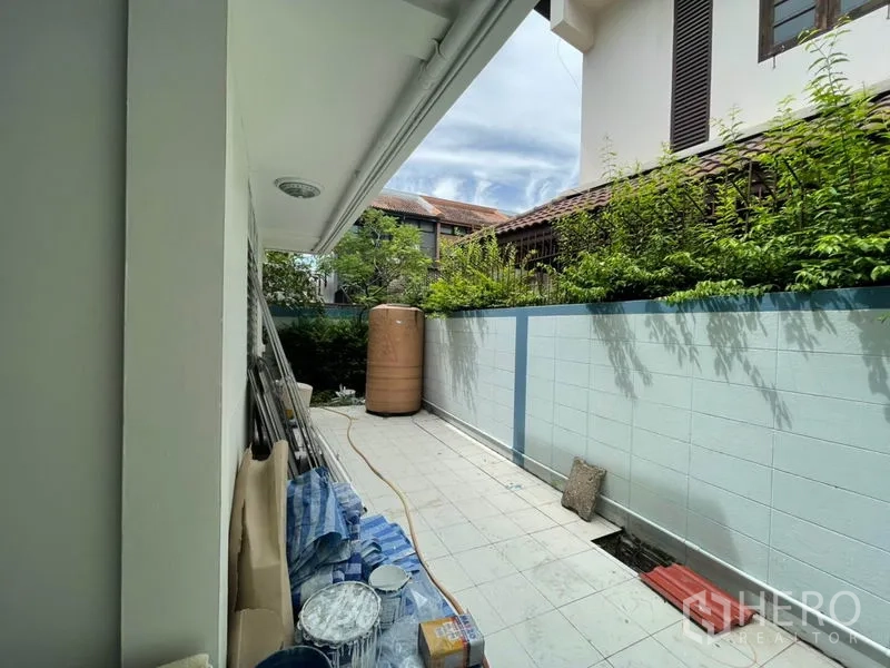 Detached House for rent in Khlong Toei, Bangkok - Rear service corridor with white wall, greenery and a water tank.