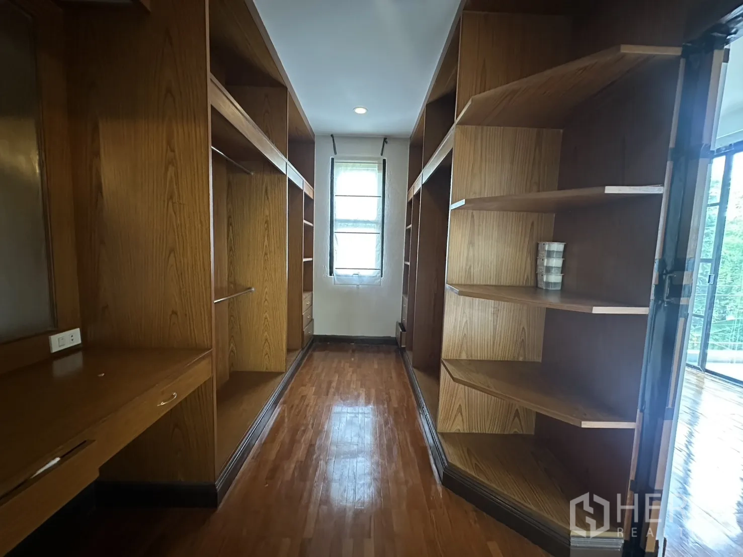 Detached House for rent in Watthana, Bangkok - Walk-in closet with built-in wooden shelves, desk, and storage.