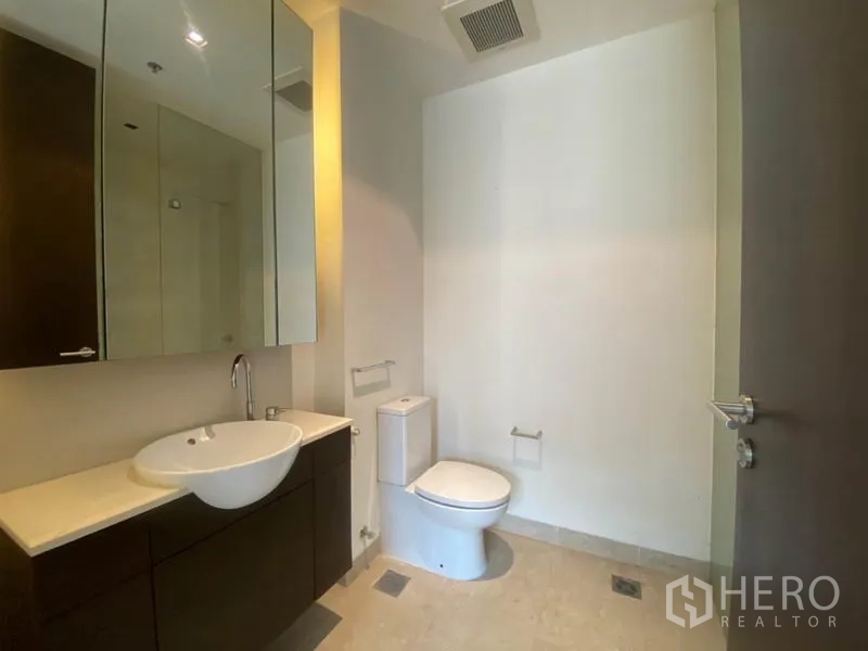 公寓 出租在Yan Nawa, Bangkok - 卫浴配镜柜、台盆与坐便器。