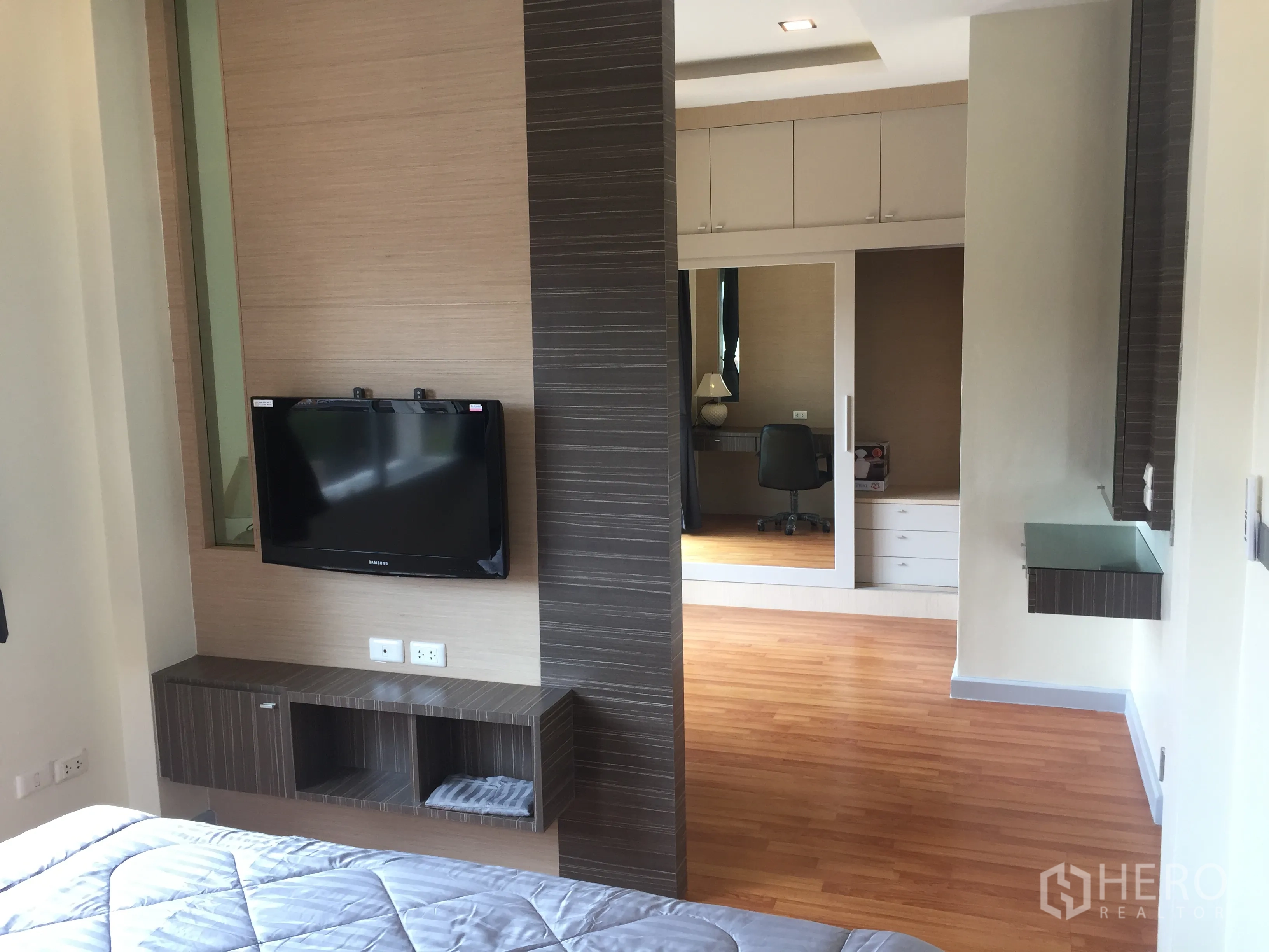 Detached House for sale in Lat Krabang, Bangkok - Master suite view with wall-mounted TV, wardrobe with mirror and study area.