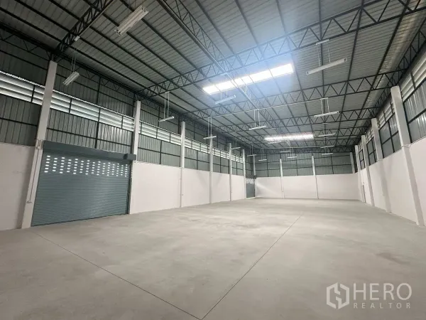工厂 出租在Bang Len, Nakhon Pathom - 宽敞仓库内景，混凝土地面与大型卷闸门