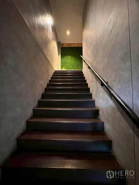 Warehouse for rent in Prawet, Bangkok - Staircase with dark steps and handrail leading to the upper office level.