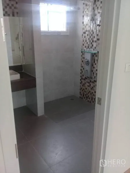 Home Office for rent in Bang Na, Bangkok - Bathroom with walk-in shower, mosaic wall tiles, and a vanity beneath a window.