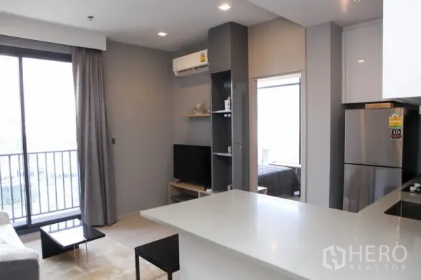 คอนโด ให้เช่าในWatthana, Bangkok - ห้องนั่งเล่นแบบเปิดโล่งมีระเบียง ทีวี และเคาน์เตอร์บาร์ ในคอนโดสมัยใหม่