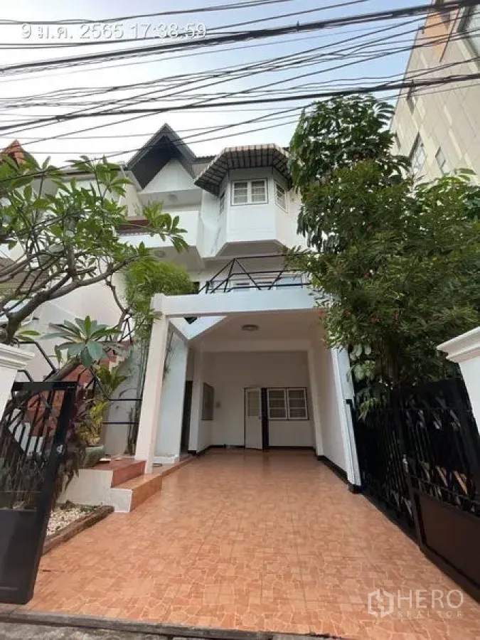 บ้าน ให้เช่าในKhlong Toei, Bangkok - บ้านเดี่ยวหลายชั้นด้านหน้าพร้อมที่จอดรถปูกระเบื้อง ประตูรั้ว และต้นไม้ใหญ่