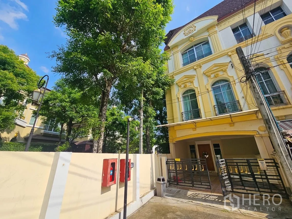 ทาวน์เฮาส์ for rent in Yan Nawa, Bangkok - ภายนอกทาวน์เฮ้าส์หัวมุมสีเหลือง ประตูกำแพงและต้นไม้ใหญ่